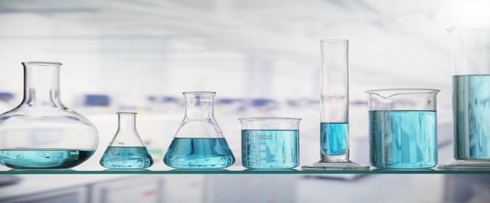 Beakers with solution on shelf in lab